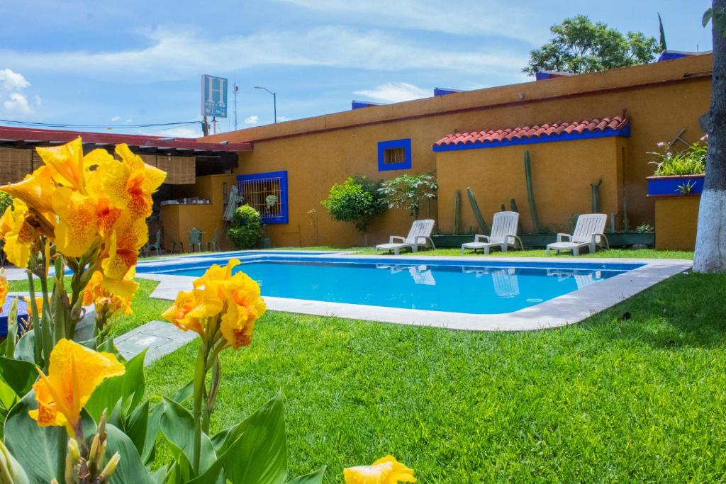 a house with a swimming pool in the yard at Hotel Hacienda Don Cenobio in San Pablo Villa de Mitla