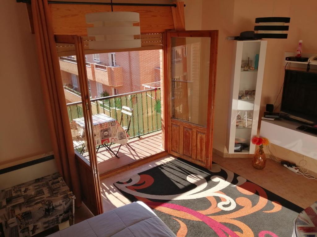 a living room with a door and a rug at Habitación privada, siéntete como en tu casa in Manzanares el Real