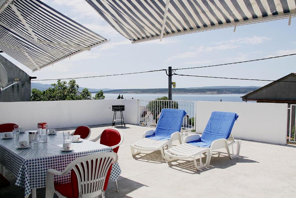 a patio with a table and chairs and a view of the water at House Zara in Maslenica