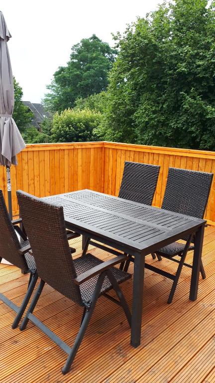 una mesa y sillas en una terraza con sombrilla en Sonnenschein en Uelzen