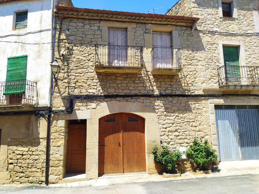 an old stone building with two doors and windows at Cal Ferrer de Tarres in Tarrés