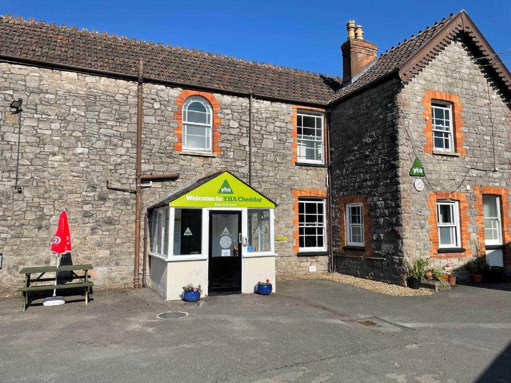 un bâtiment avec un auvent jaune devant lui dans l'établissement YHA Cheddar, à Cheddar