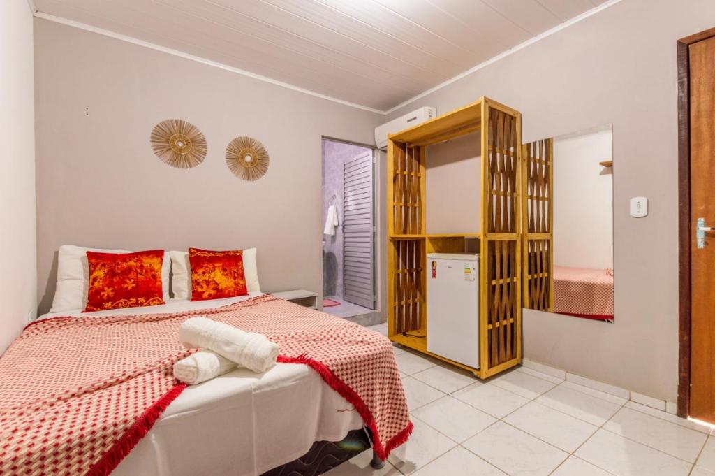 1 dormitorio con 1 cama con manta roja y blanca en Pousada Porto Milagres-São Miguel dos Milagres-AL, en São Miguel dos Milagres