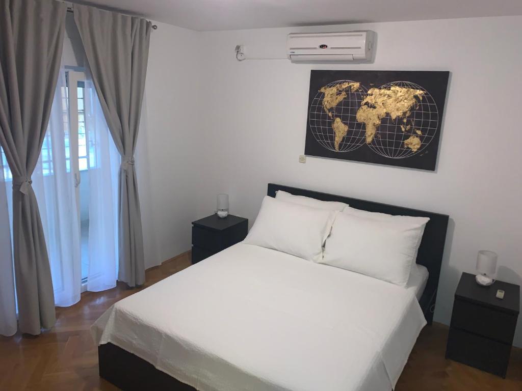 - une chambre avec un lit blanc et une carte murale dans l'établissement MladenG, à Trogir