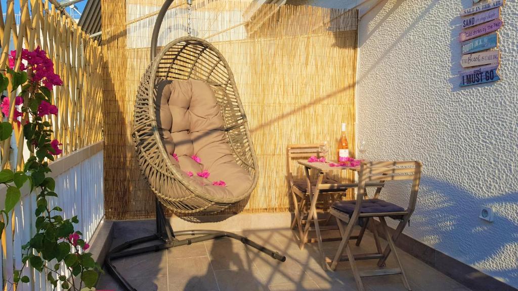eine Veranda mit einer Hängematte auf einem Balkon mit einem Tisch in der Unterkunft WOW Penthouse Boutique in the heart of Historical Center in Athen