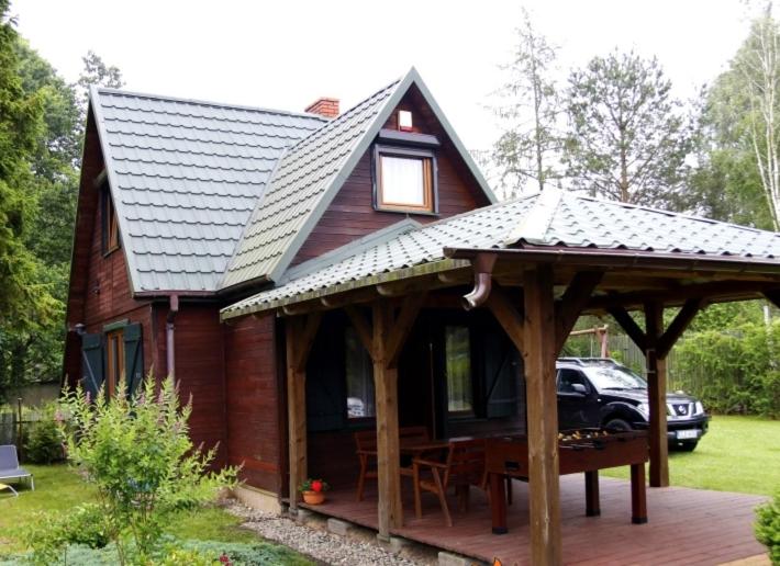 a house with a pavilion with a table in front of it at Domek Letniskowy in Lubiatowo