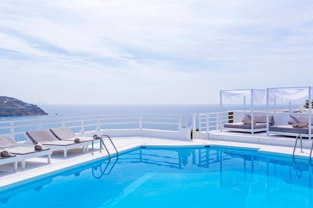 una piscina en un crucero con sillas y una piscina en Pietra e Mare - Mykonos Moments en Kalo Livadi