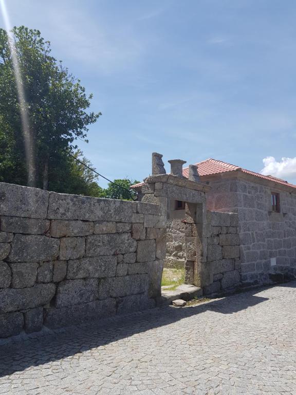 un mur en pierre à côté d'un bâtiment en pierre dans l'établissement Casa da Relva inspirado em Harry Potter, à Lamego