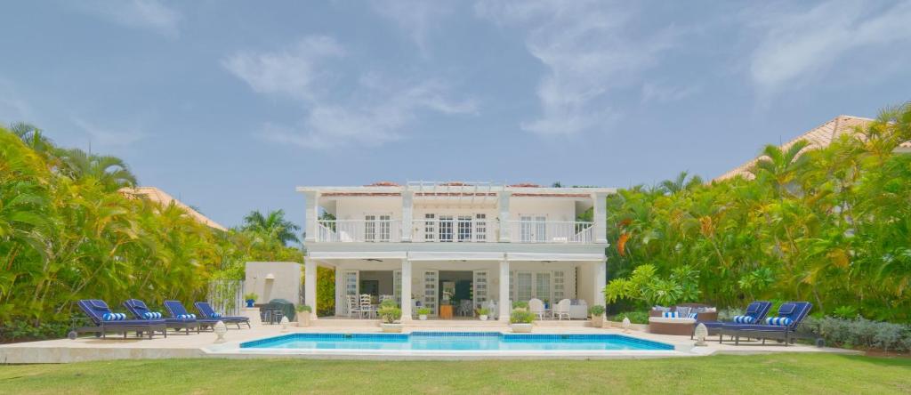 una casa grande con piscina frente a ella en Cozy 4BDR villa in luxury beach resort with service staff and view of La Cana golf course, en Punta Cana