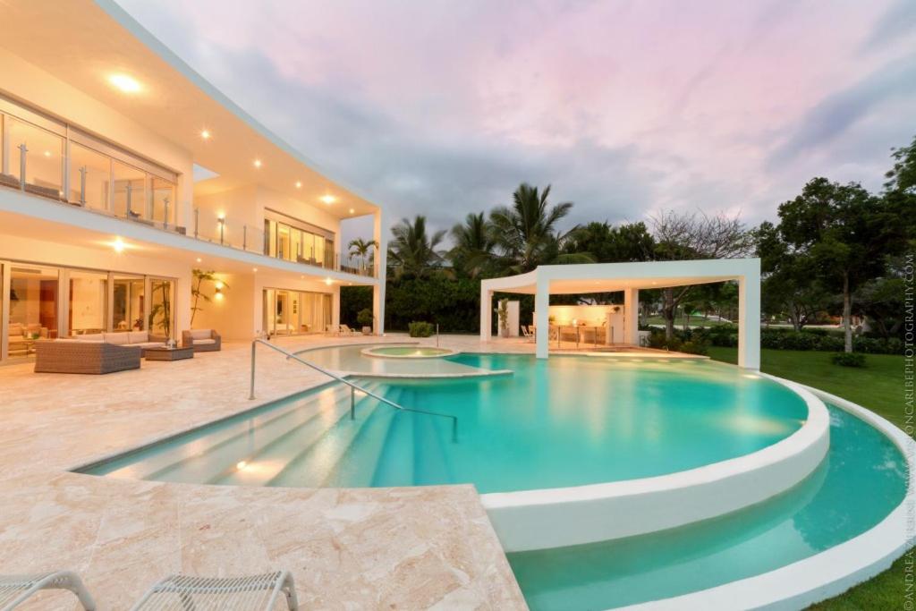 a large swimming pool in the backyard of a house at Luxury 5-room modern villa with movie theater at exclusive Punta Cana golf and beach resort in Punta Cana