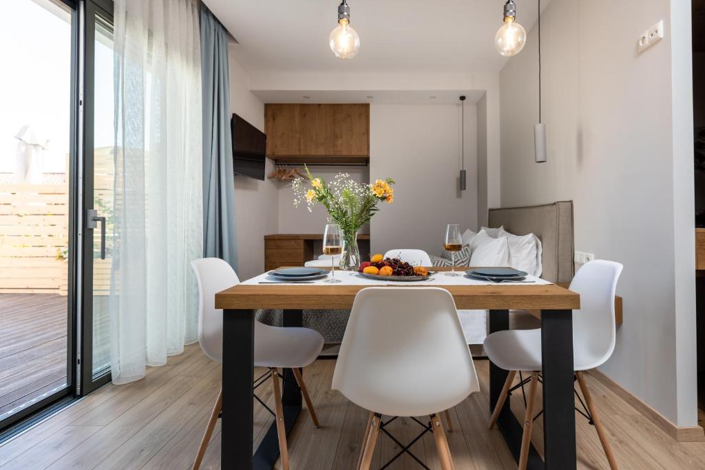a kitchen and dining room with a table and chairs at Melcon Luxury Suites in Parga