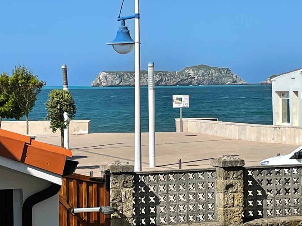 ein Straßenlicht neben dem Meer mit einem Gebäude in der Unterkunft La Playa Suites Suances in Suances