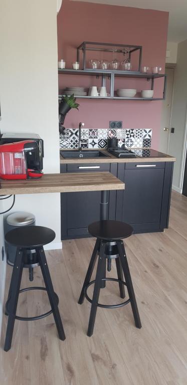 une cuisine avec une table en bois et deux tabourets dans l'établissement Le yacht club1, à Blonville-sur-Mer