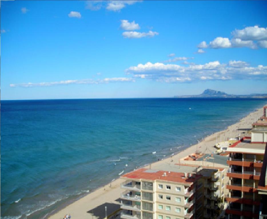 a view of a beach with buildings and the ocean at Apartamento junto al mar in Bellreguart