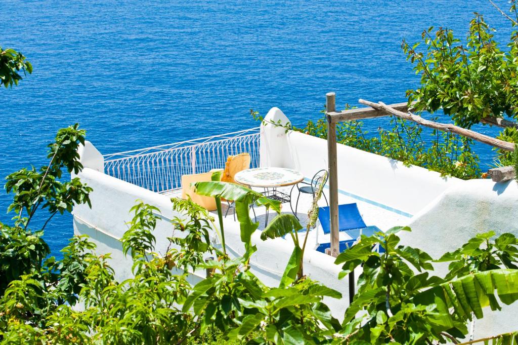 a table and chairs on a balcony overlooking the ocean at Hotel Costa Diva in Praiano