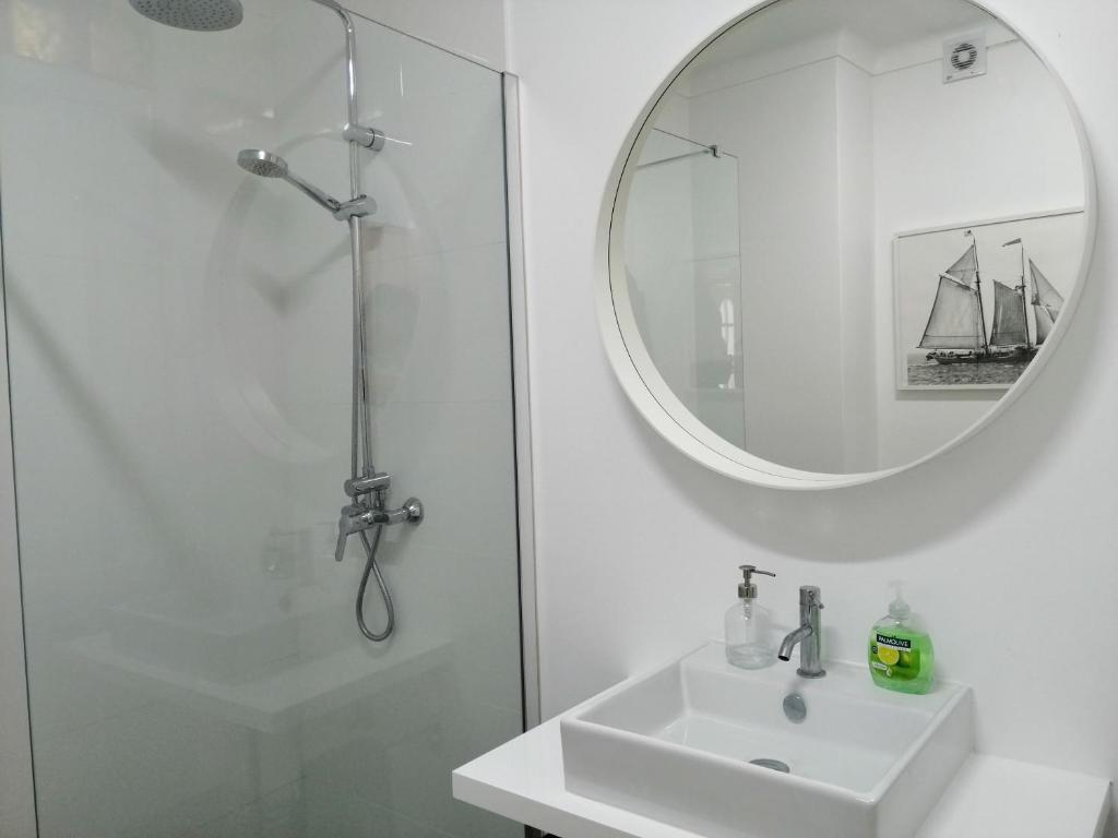 un bagno bianco con lavandino e specchio di House with a view ad Alcácer do Sal