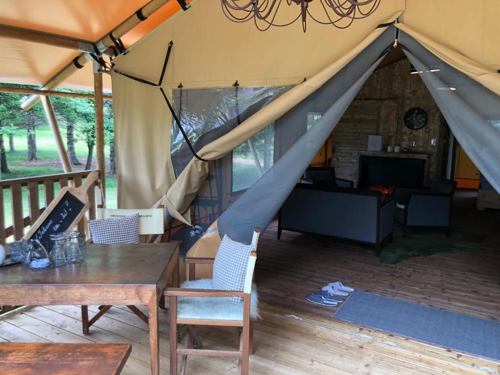 Zelt mit einem Tisch und Stühlen sowie einem Esszimmer in der Unterkunft GIFFORD private Island GLAMPING boat ride included in Mahone Bay