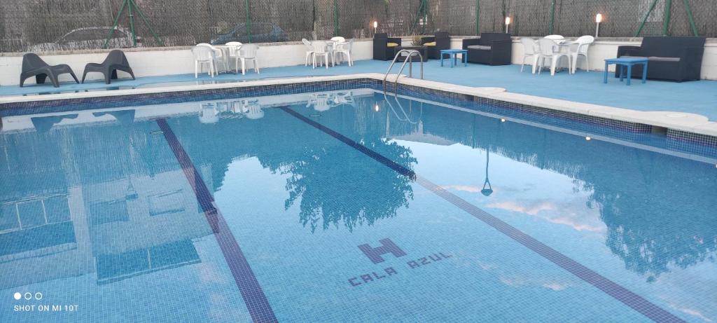 una piscina con reflejo en el agua en Apartamentos Cala Azul La Móra en Tarragona