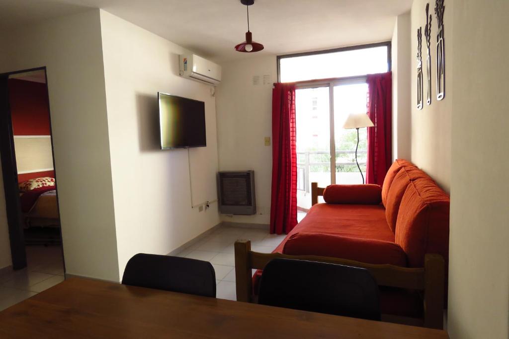 - un salon avec un canapé rouge et une fenêtre dans l'établissement Depto con fantástica TERRAZA PRIVADA en pleno centro, à Córdoba
