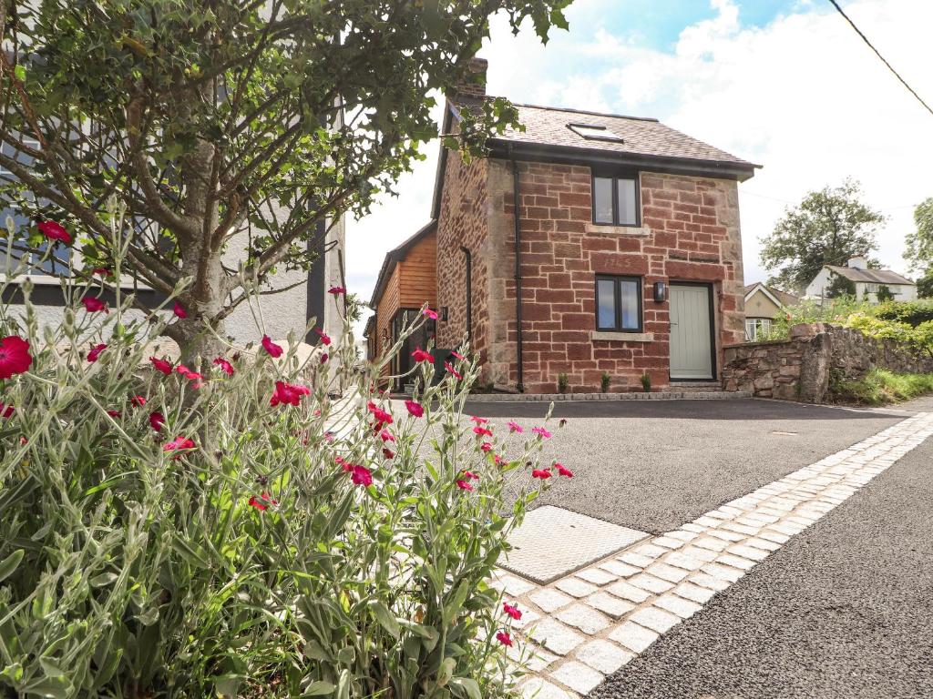 a brick house with flowers in front of it at Ty Coch in Ruthin