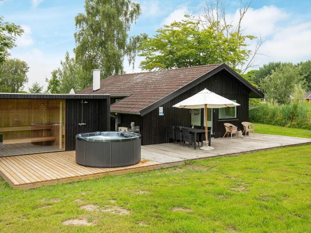 Bøtø Byにある6 person holiday home in Idestrupのウッドデッキにホットタブが付いています。