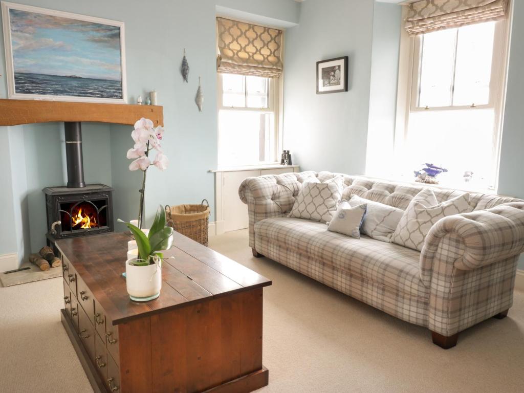 a living room with a couch and a fireplace at Invermay in Anstruther