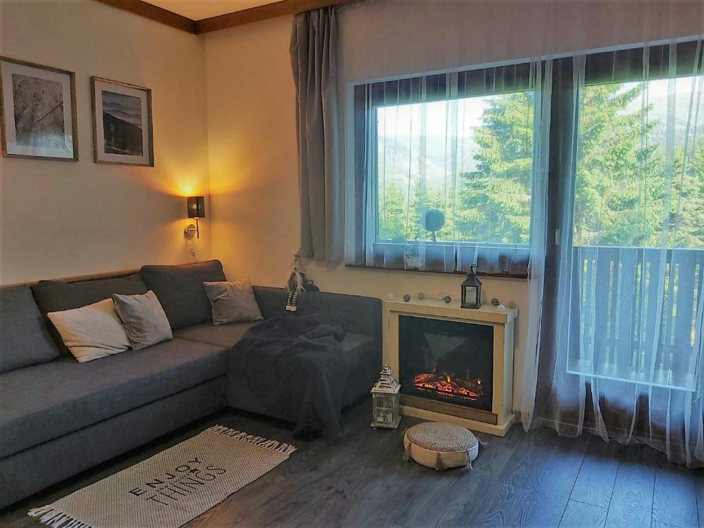 sala de estar con sofá y chimenea en Korlape Apartman 4.2, en Wolfsberg