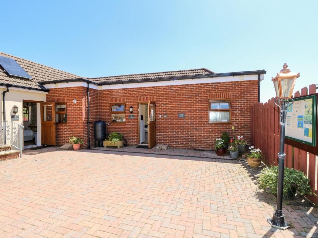 a brick house with a brick driveway at 3 The Stables in Haven Street