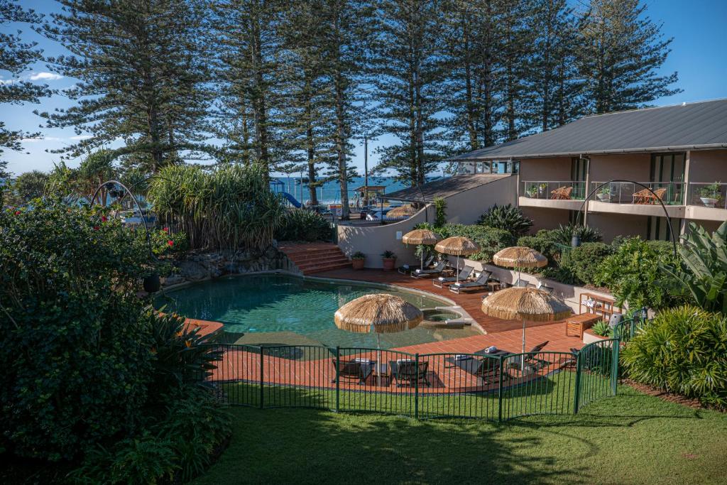 una piscina con sombrillas y un complejo en Beach Hotel Resort, en Byron Bay