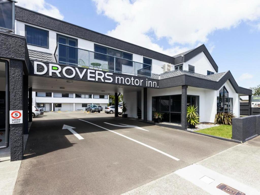 a building with a sign that reads queens motor inn at Drovers Motor Inn in Palmerston North