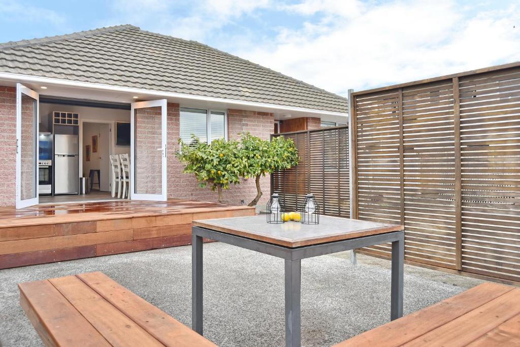 eine Terrasse mit einem Tisch vor einem Haus in der Unterkunft Brockworth Place - Christchurch Holiday Homes in Christchurch