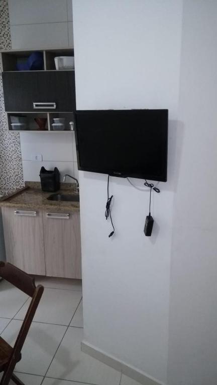 a television sitting on top of a white counter in a kitchen at Apartamento a 50 metros da praia in Ubatuba