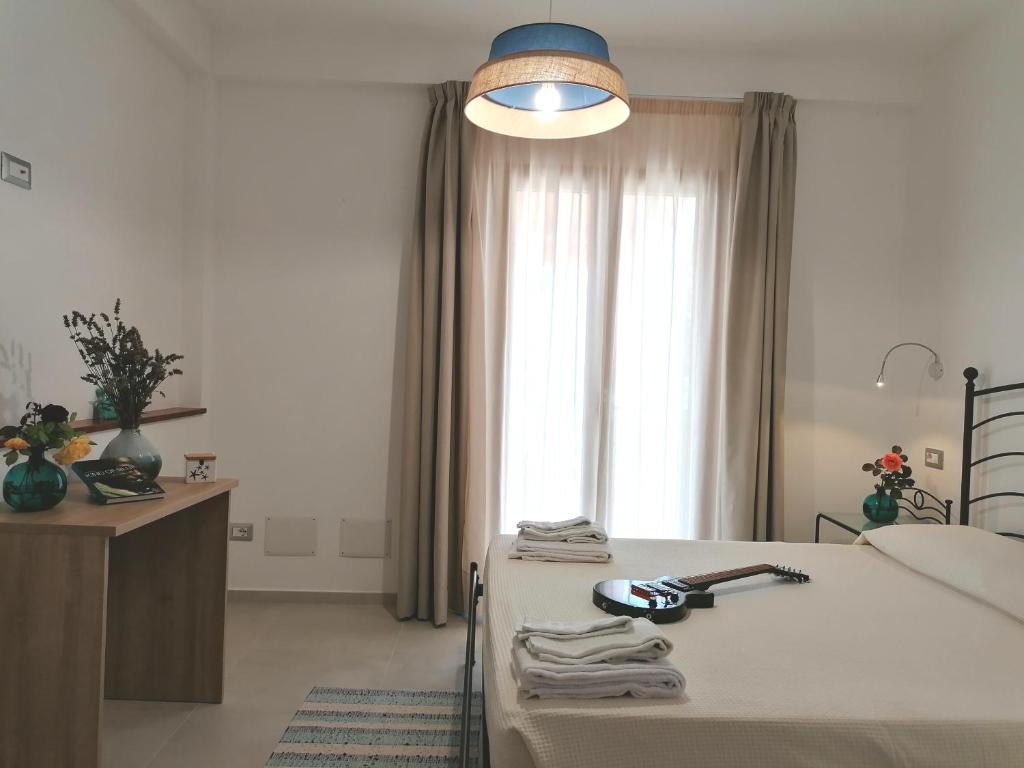 a bedroom with a bed with a lamp and a window at Body and Soul in Cala Gonone