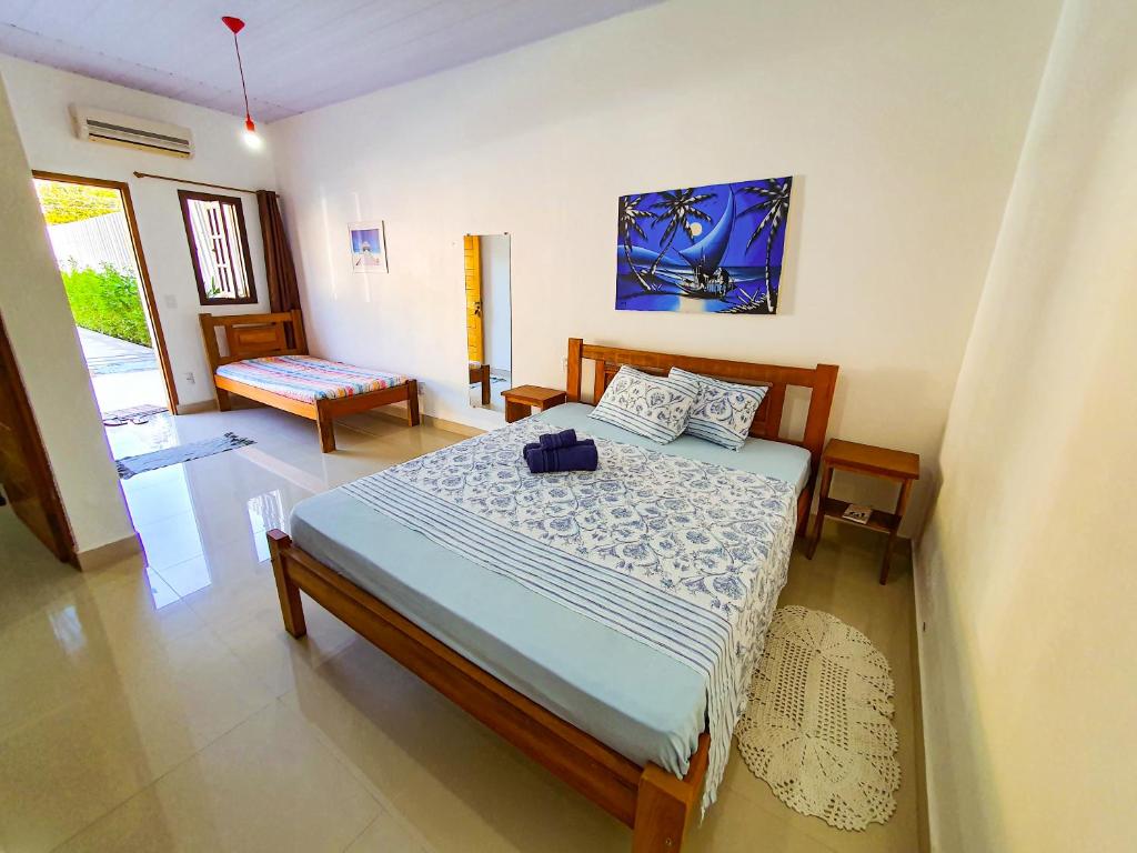 um quarto com uma cama com um edredão azul em Guest House Della Vita em Ilhabela