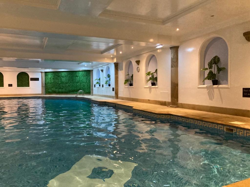 a swimming pool in a hotel with a green screen at Washington Central Hotel and Sleepwell Inn in Workington