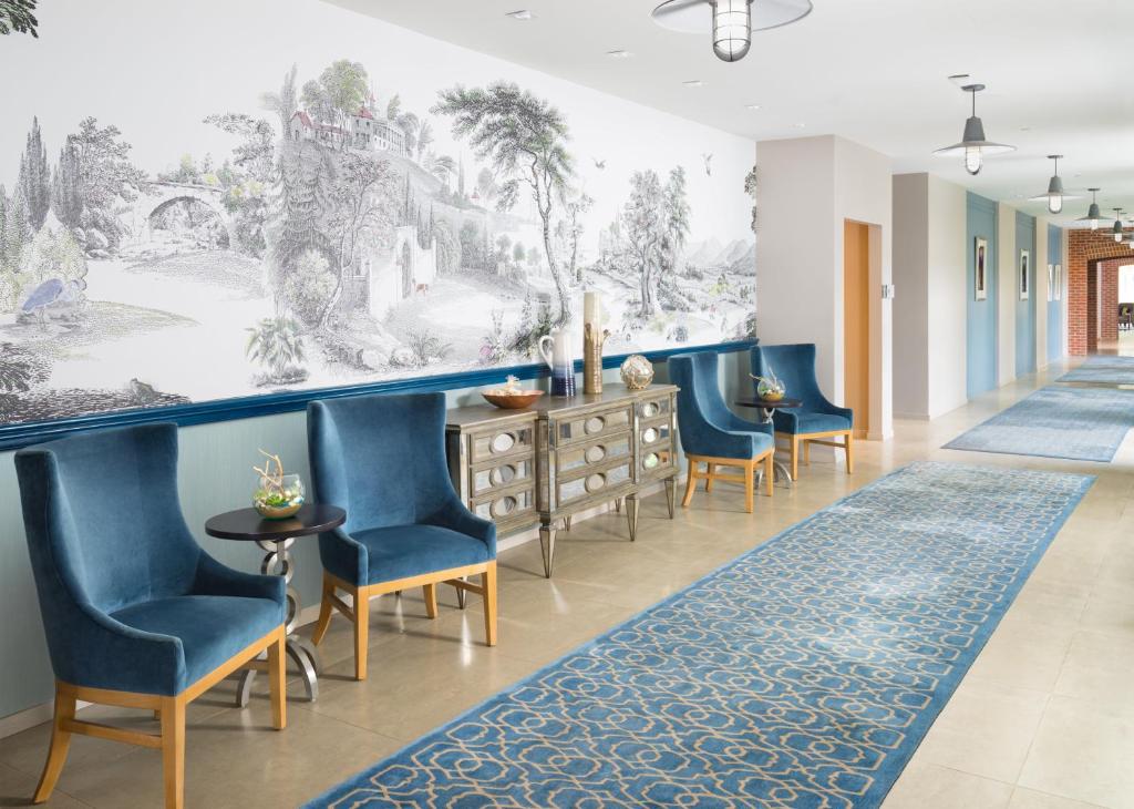 a hallway with blue chairs and a wall mural at Hotel Indigo Old Town Alexandria, an IHG Hotel in Alexandria