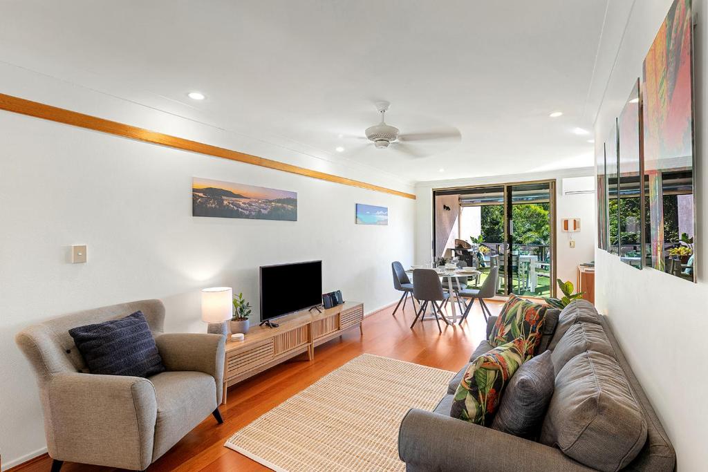 a living room with a couch and a tv at Montipora Unit 3 - In the heart of Airlie, wi-fi and Netflix in Airlie Beach