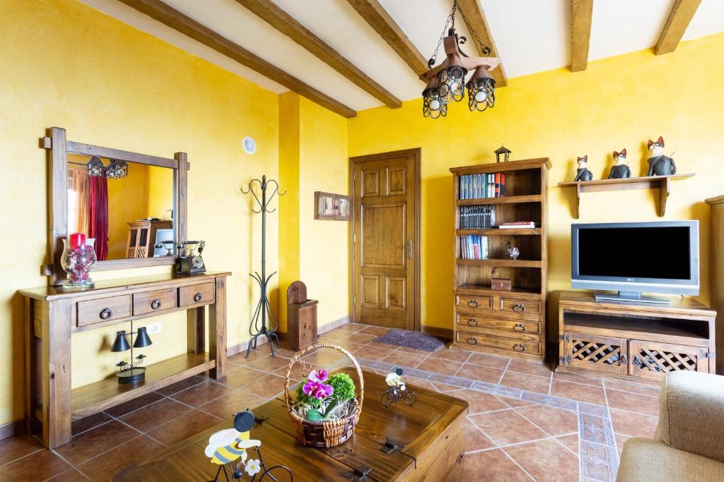 sala de estar con paredes amarillas y TV de pantalla plana. en Home2Book Charming Apartment Los Realejos, en Los Realejos