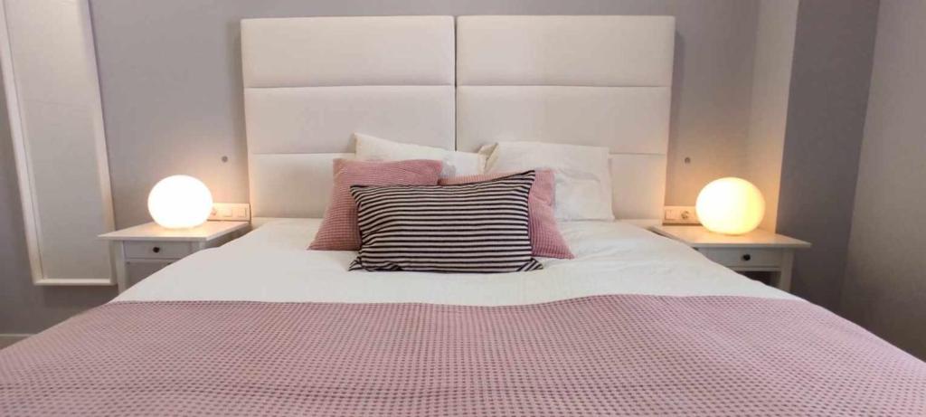 1 dormitorio con 1 cama con 2 lámparas en ambos lados en GRUPO LIMCOTEL PERLAS dE LA AXERQUIA, en Córdoba