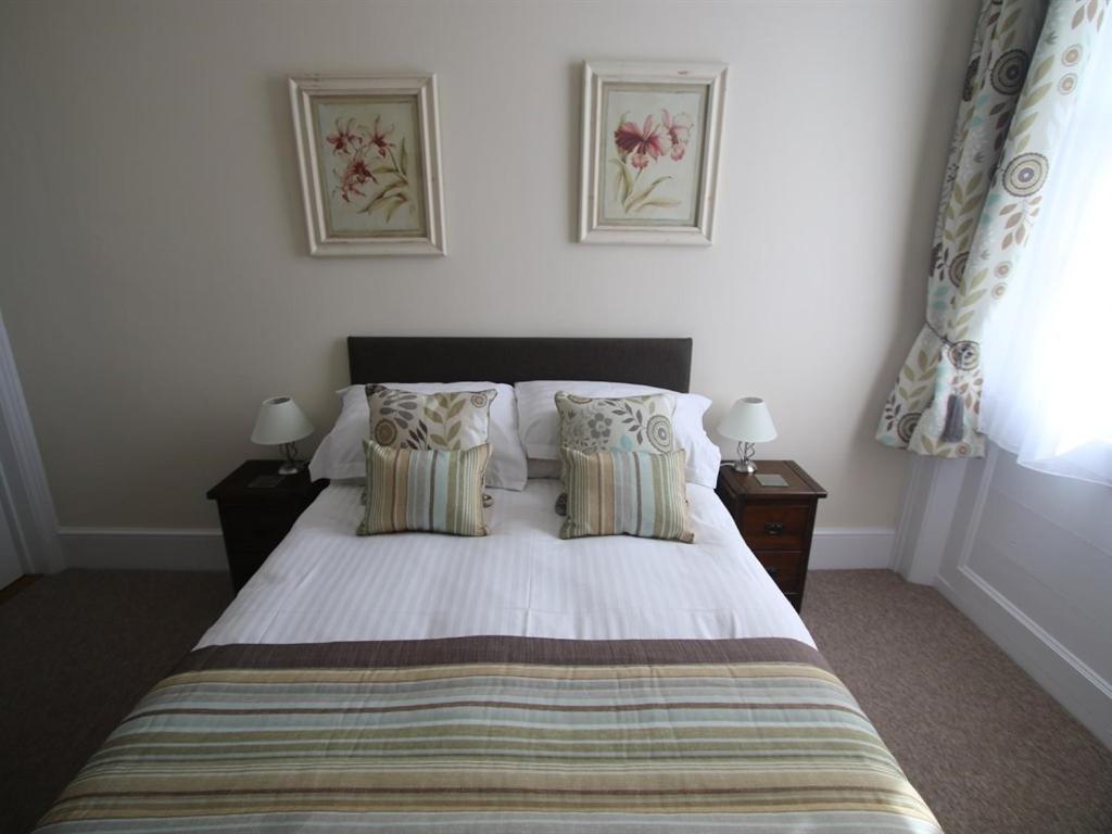 a bedroom with a large bed with two pillows at Spring Garden Apartments in Gosport