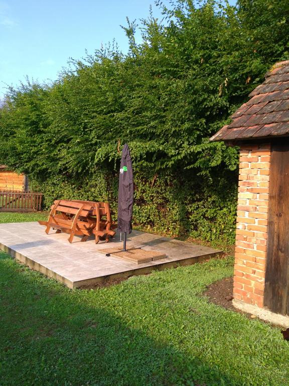 una terraza de madera con mesa y sombrilla en SandorA Vendégház Nagyrákos, en Nagyrákos