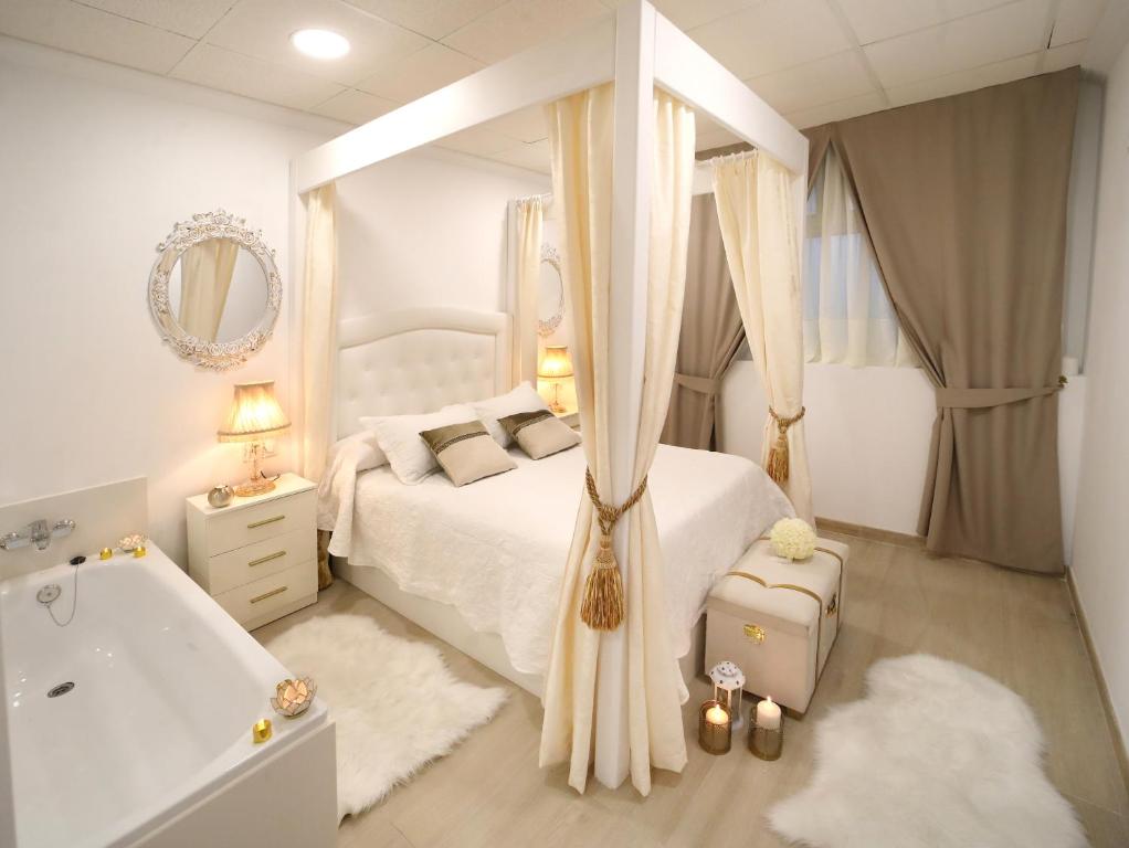 sypialnia z białym łóżkiem i wanną w obiekcie Apartamento Romero Garden B w mieście Villanueva de Arosa