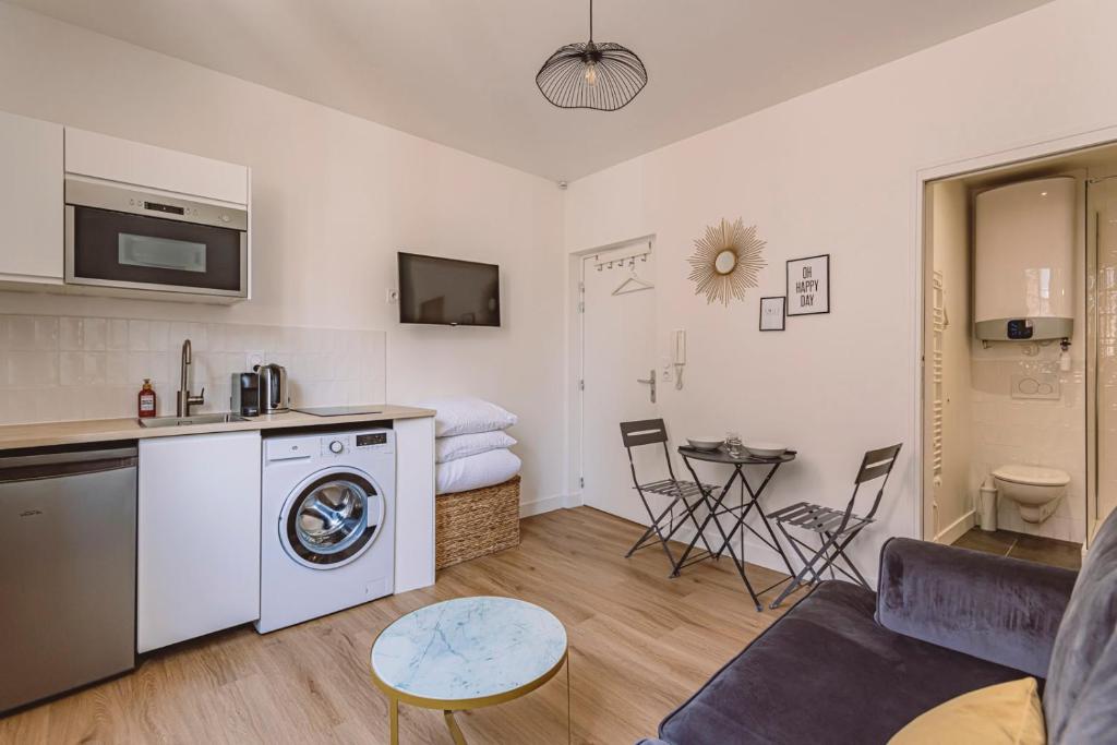 ein Wohnzimmer mit einer Küche und einer Waschmaschine in der Unterkunft Reims - City Center - Cathédrale - FORUM in Reims