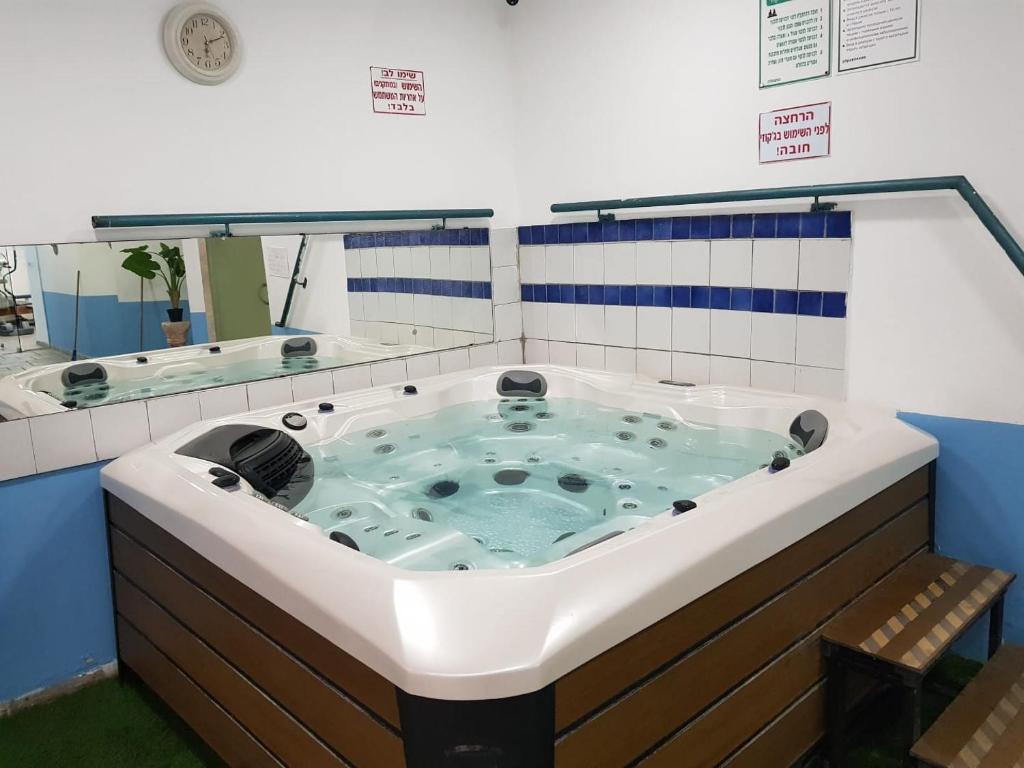 a jacuzzi tub in a bathroom with a mirror at Crazy Suite in Ashqelon