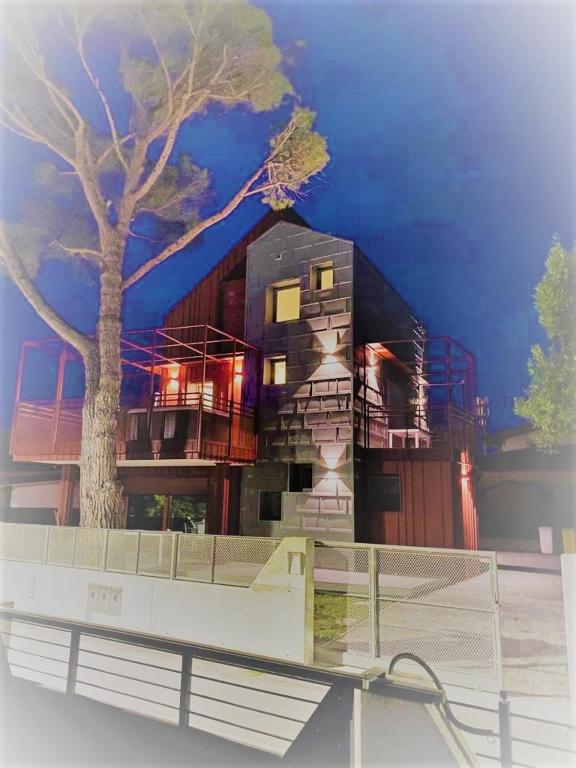 a building with a tree in front of it at Villa Cisa in Lignano Sabbiadoro