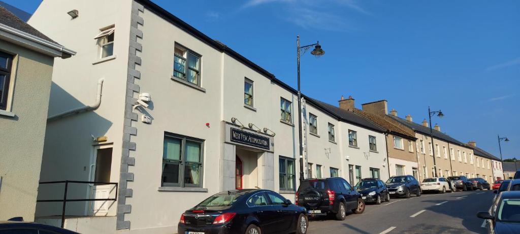 a row of buildings on a street with parked cars at West View Accomodation in Louisburgh