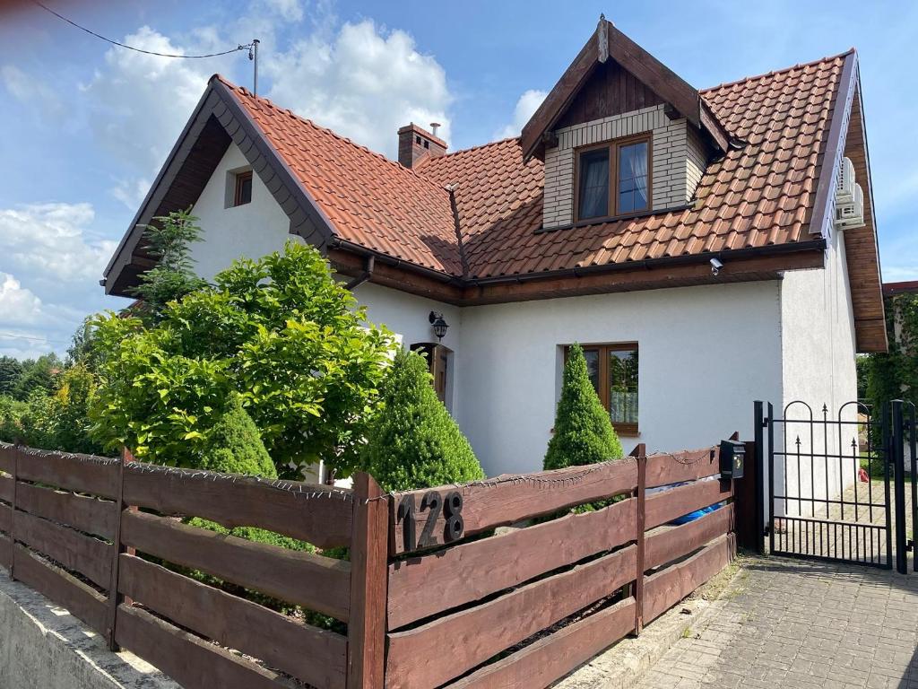 uma casa com uma cerca de madeira em frente em Na Skraju Warmii em Barczewo