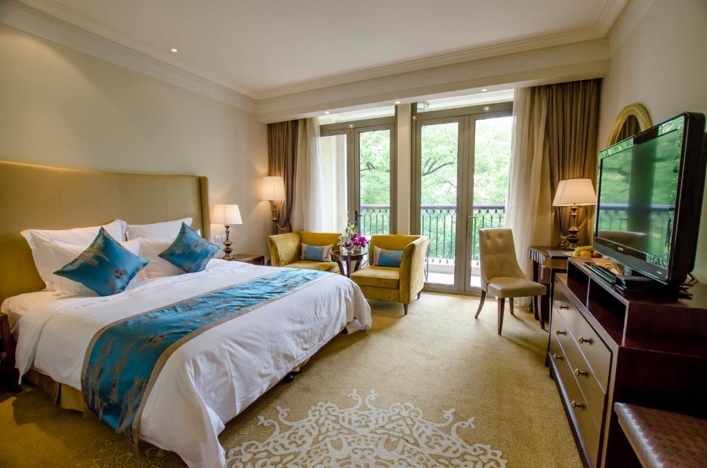 a hotel room with a bed and a television at Shanghai Fenyang Garden Boutique Hotel in Shanghai