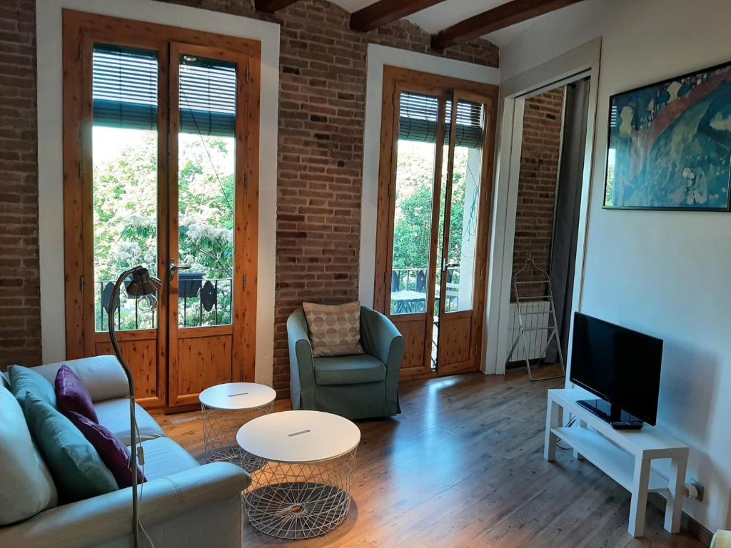 uma sala de estar com um sofá e uma televisão em OLYMPIC VILLAGE em Barcelona