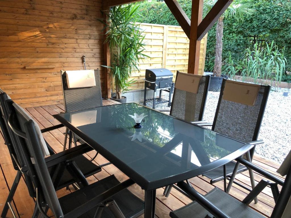 szklany stół i krzesła na patio w obiekcie Polaris Yacht Apartman w mieście Balatonalmádi